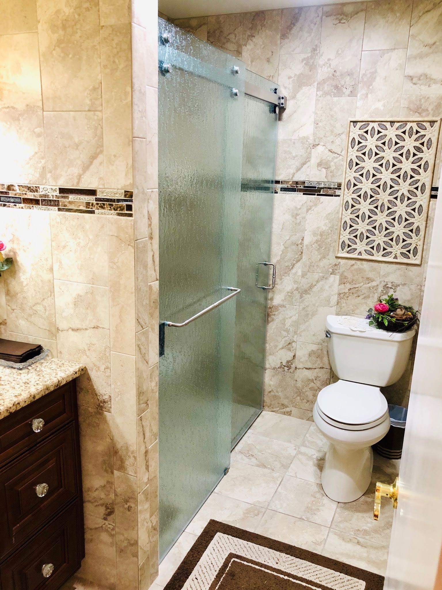 a bathroom with a toilet , sink , shower and sliding glass door.