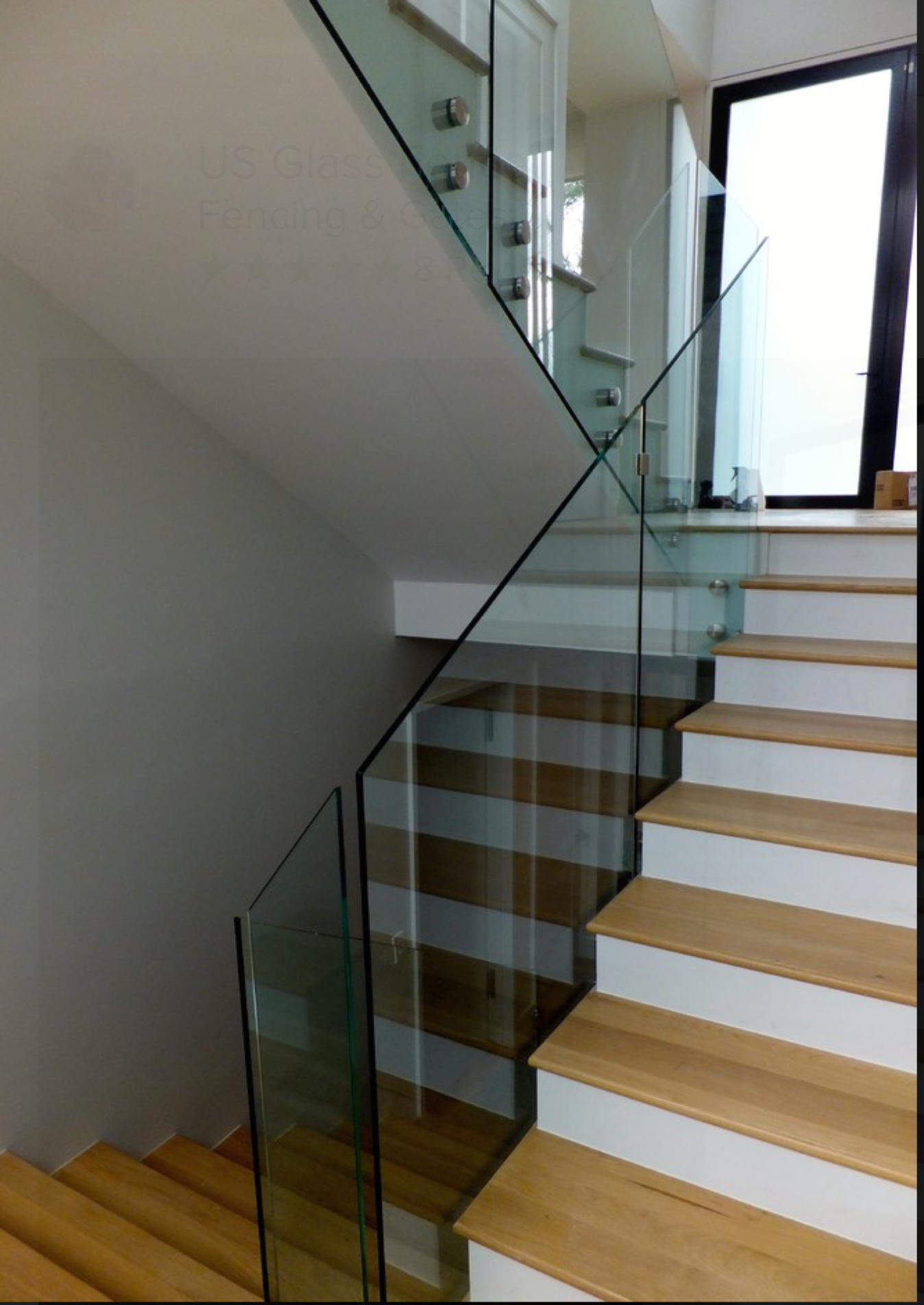 a staircase with a glass railing and wooden steps.