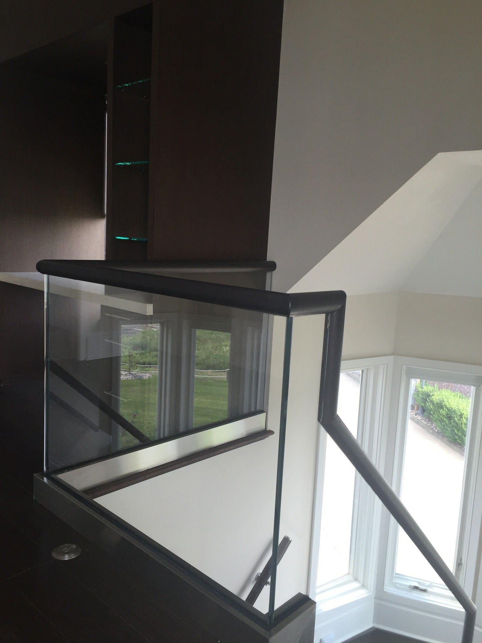 a staircase with a glass railing and a window.