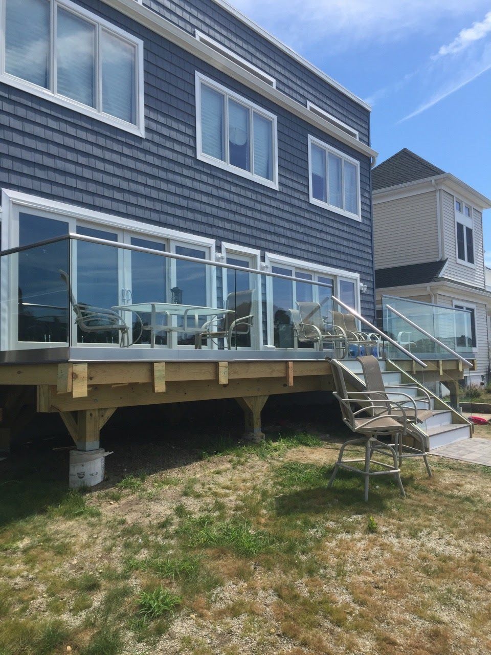 a house with a deck and stairs in front of it.