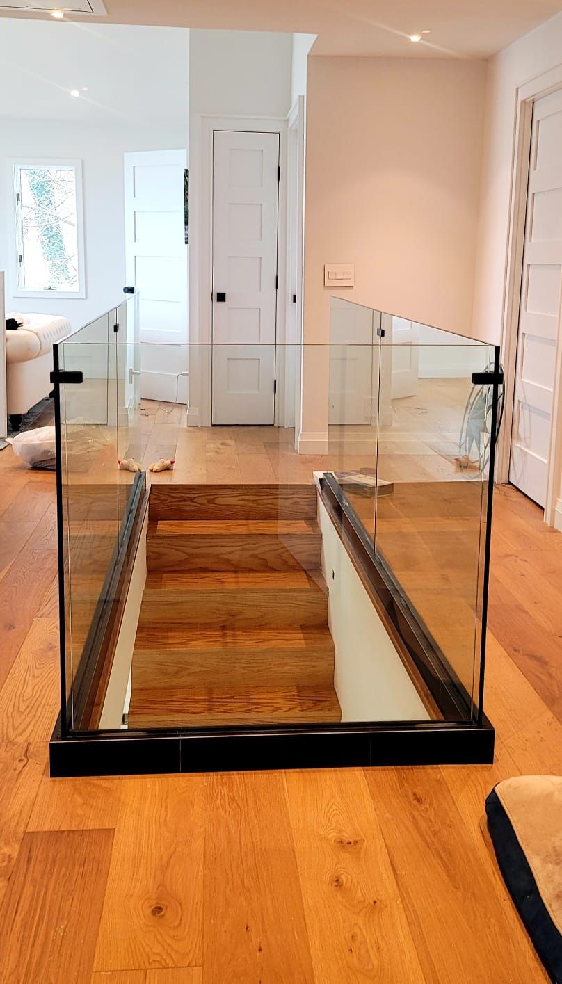 a wooden staircase with a glass railing in a house.