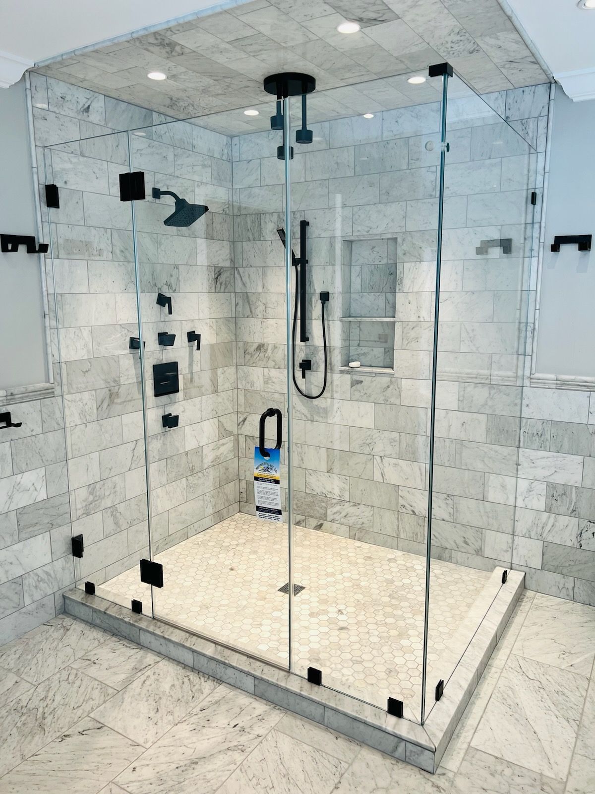 a bathroom with a walk in shower with a glass door.