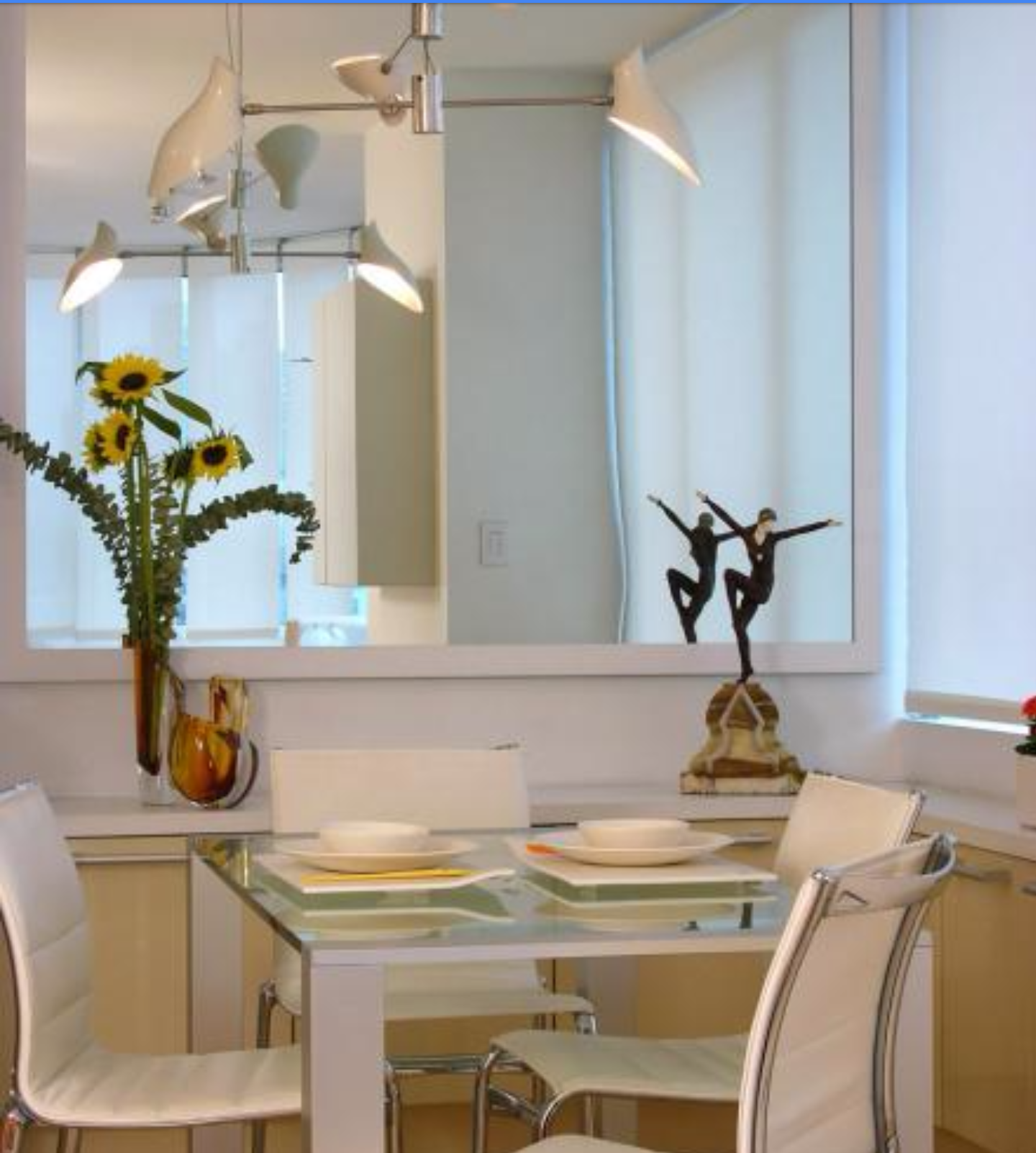 a dining room with a table and chairs and a mirror.