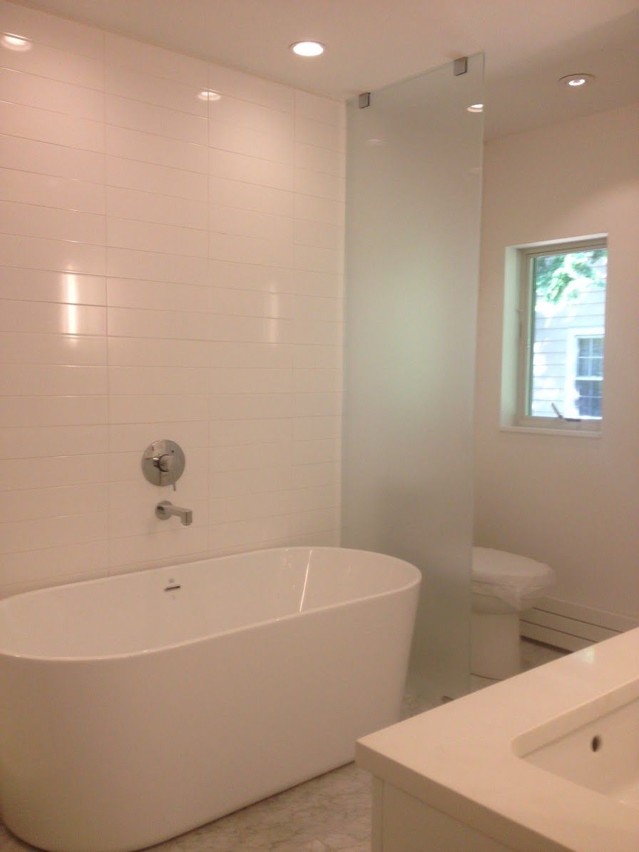 a bathroom with a tub a sink and a toilet.