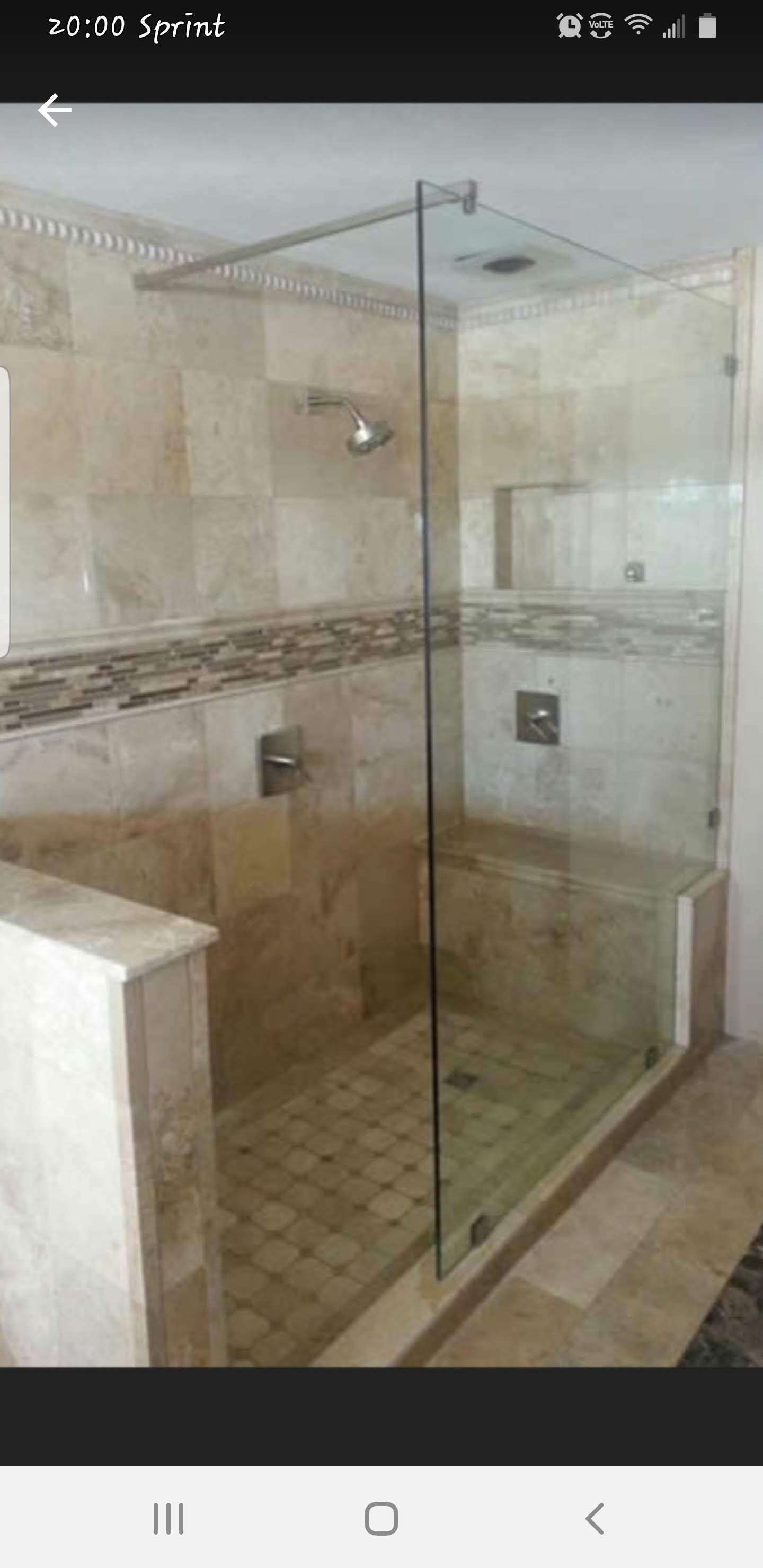 a bathroom with a walk in shower with a glass door.