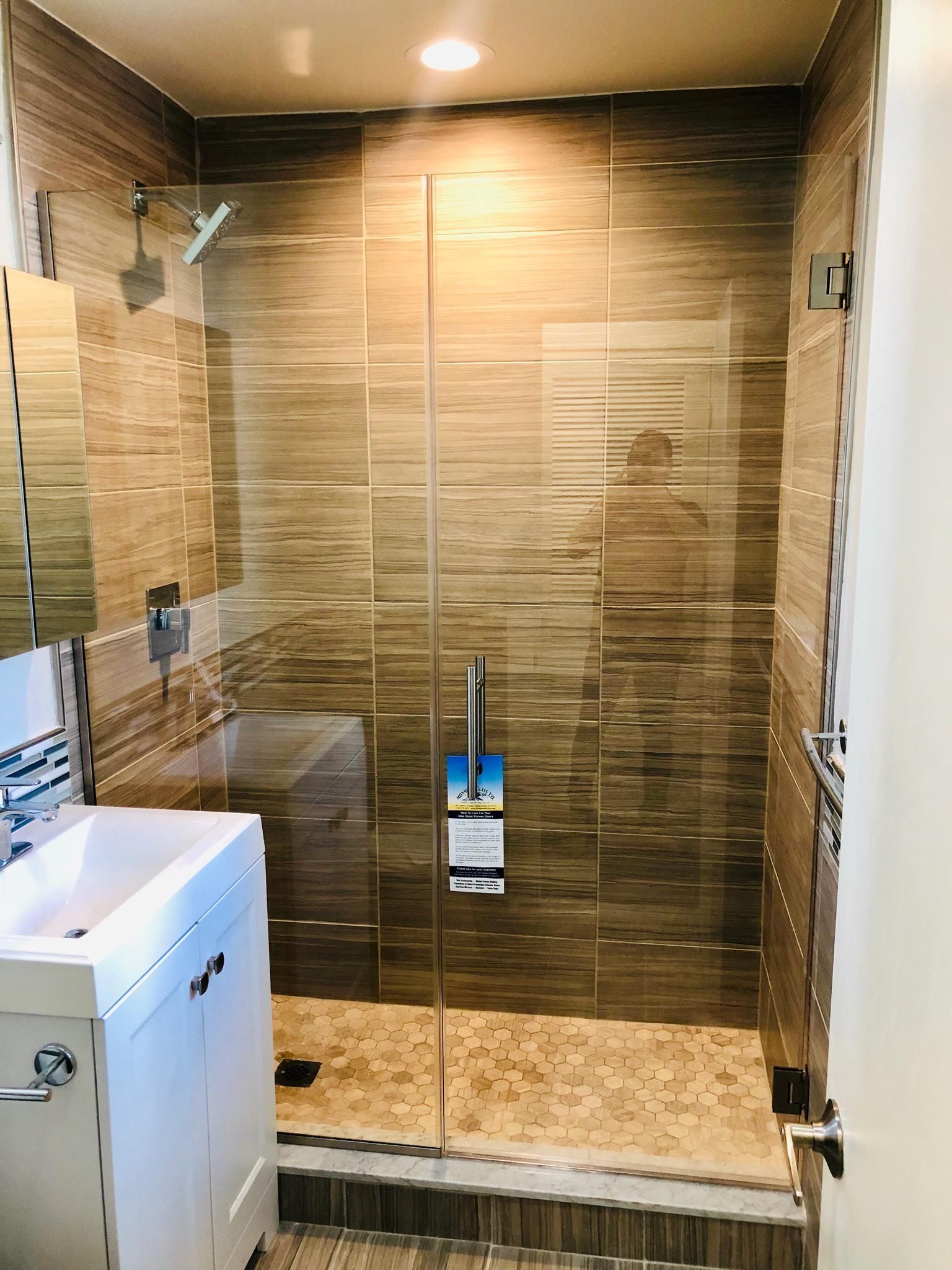 a bathroom with a walk in shower , sink and mirror.