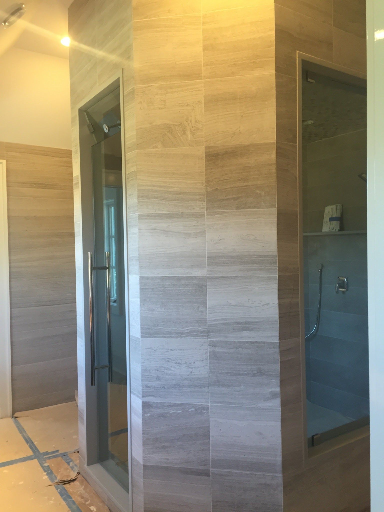 a bathroom with a walk in shower and a glass door.