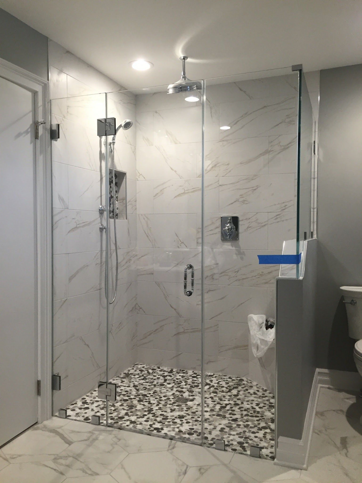 a bathroom with a walk in shower and a toilet.