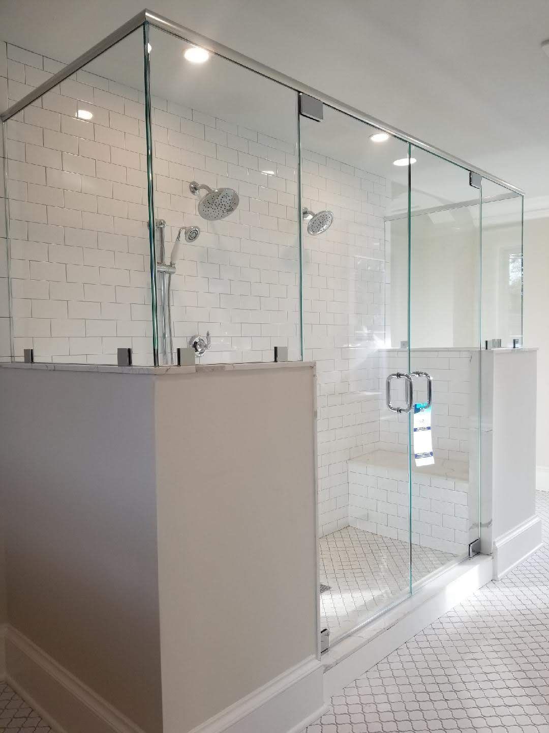 a bathroom with a walk in shower with a glass door.