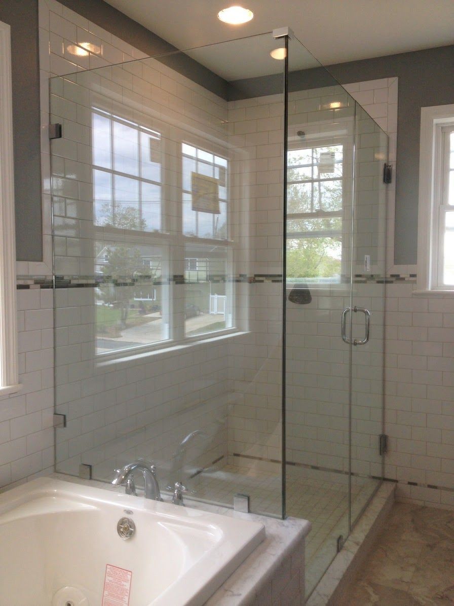 a bathroom with a tub and a shower with a glass door.
