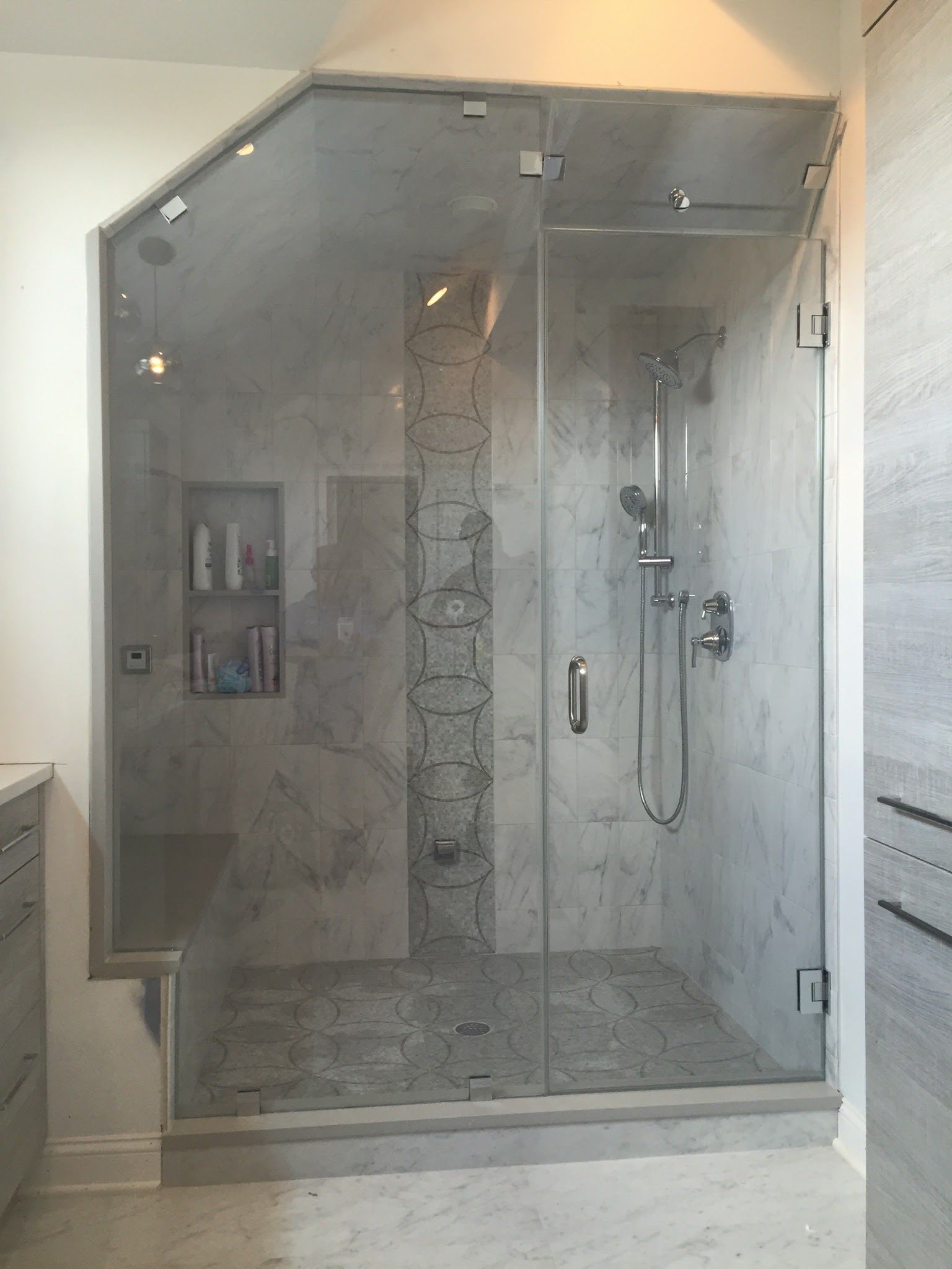 a bathroom with a walk in shower with a glass door.