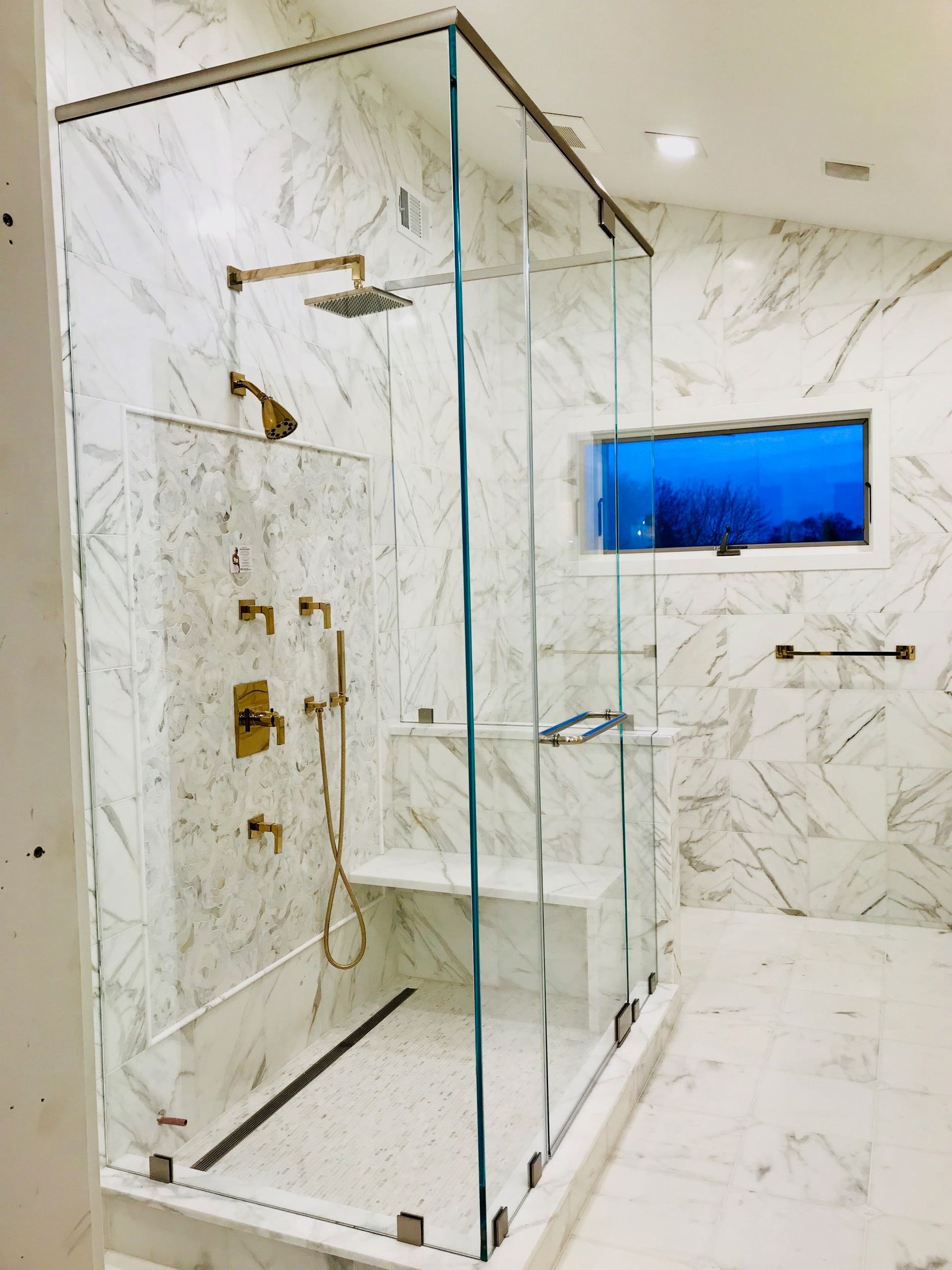 a bathroom with a walk in shower and a window.