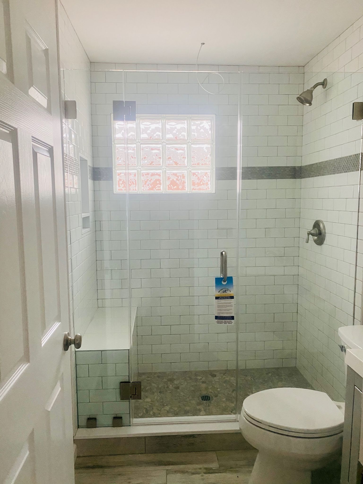 a bathroom with a toilet , sink , shower and window.