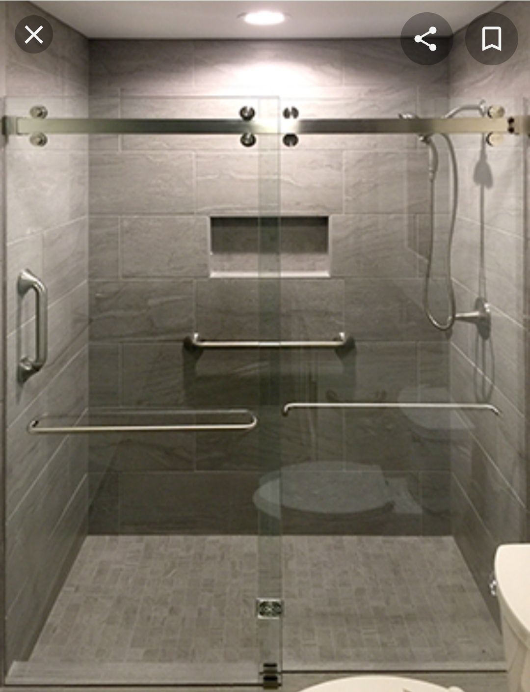 a bathroom with a sliding glass shower door and a toilet.