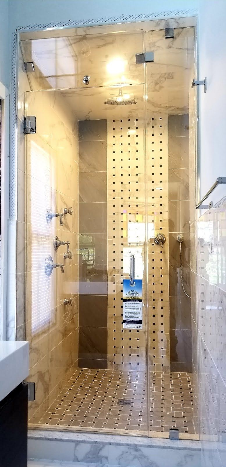 a bathroom with a walk in shower with a glass door.