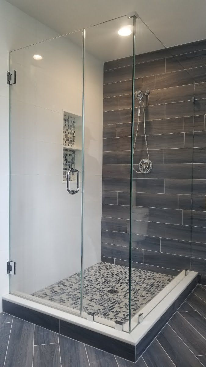 a bathroom with a walk in shower with a glass door.
