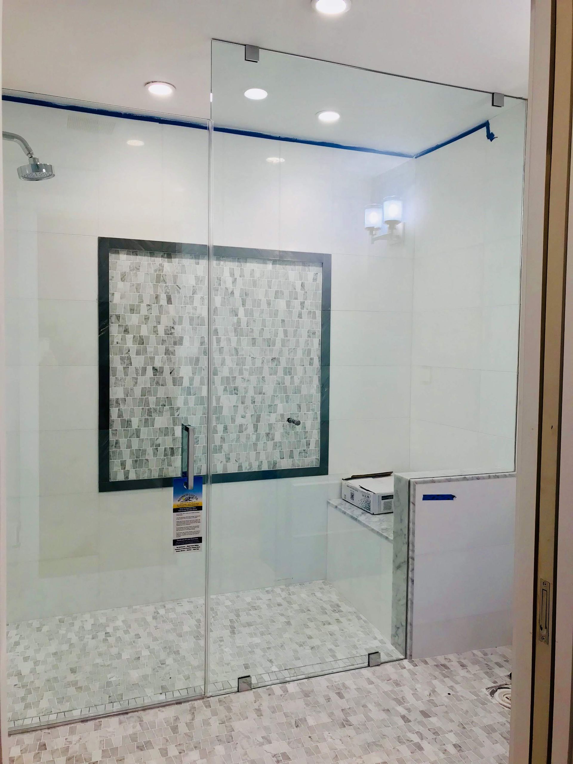 a bathroom with a walk in shower with a glass door.