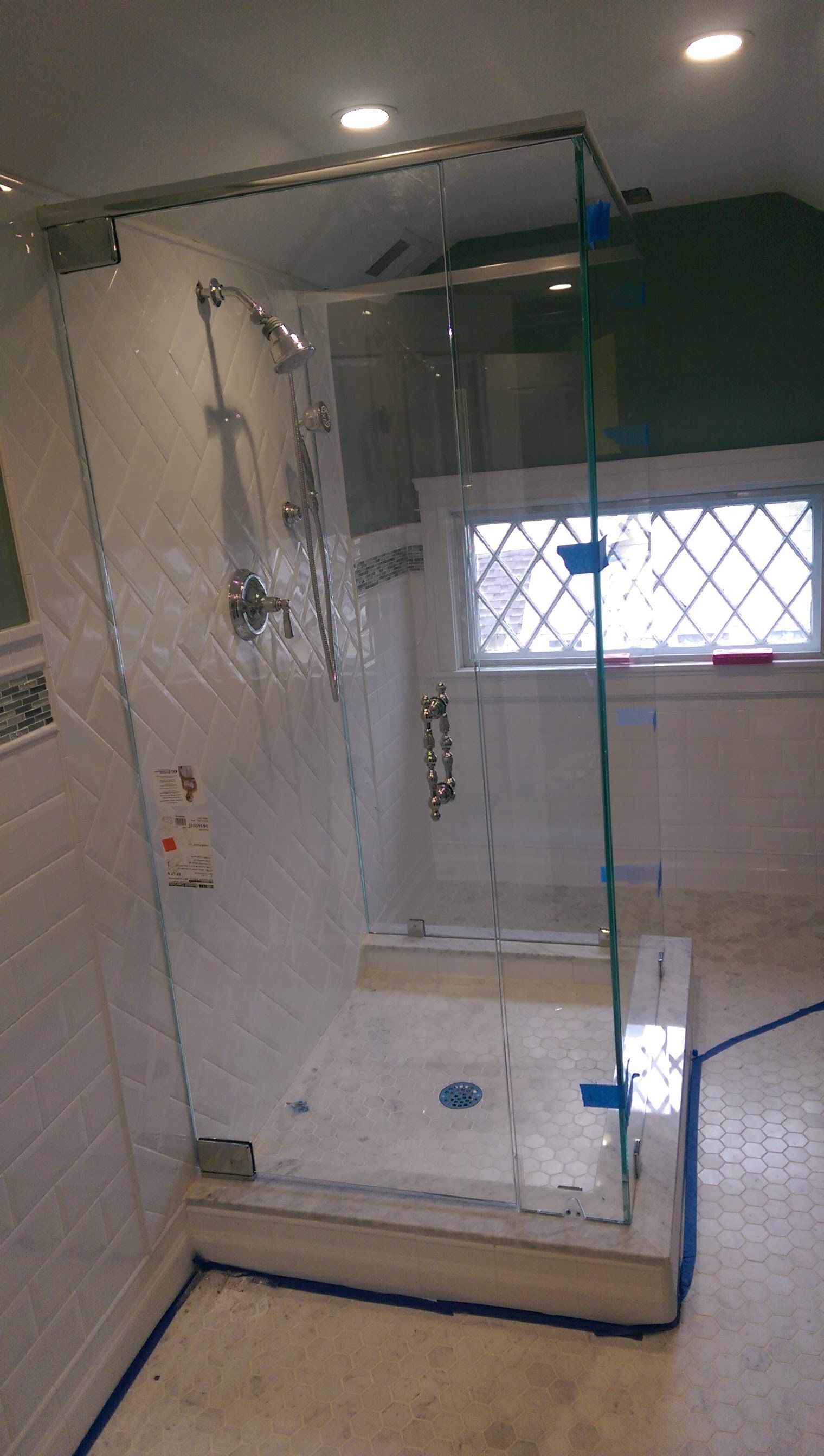 a bathroom with a shower stall and a window.