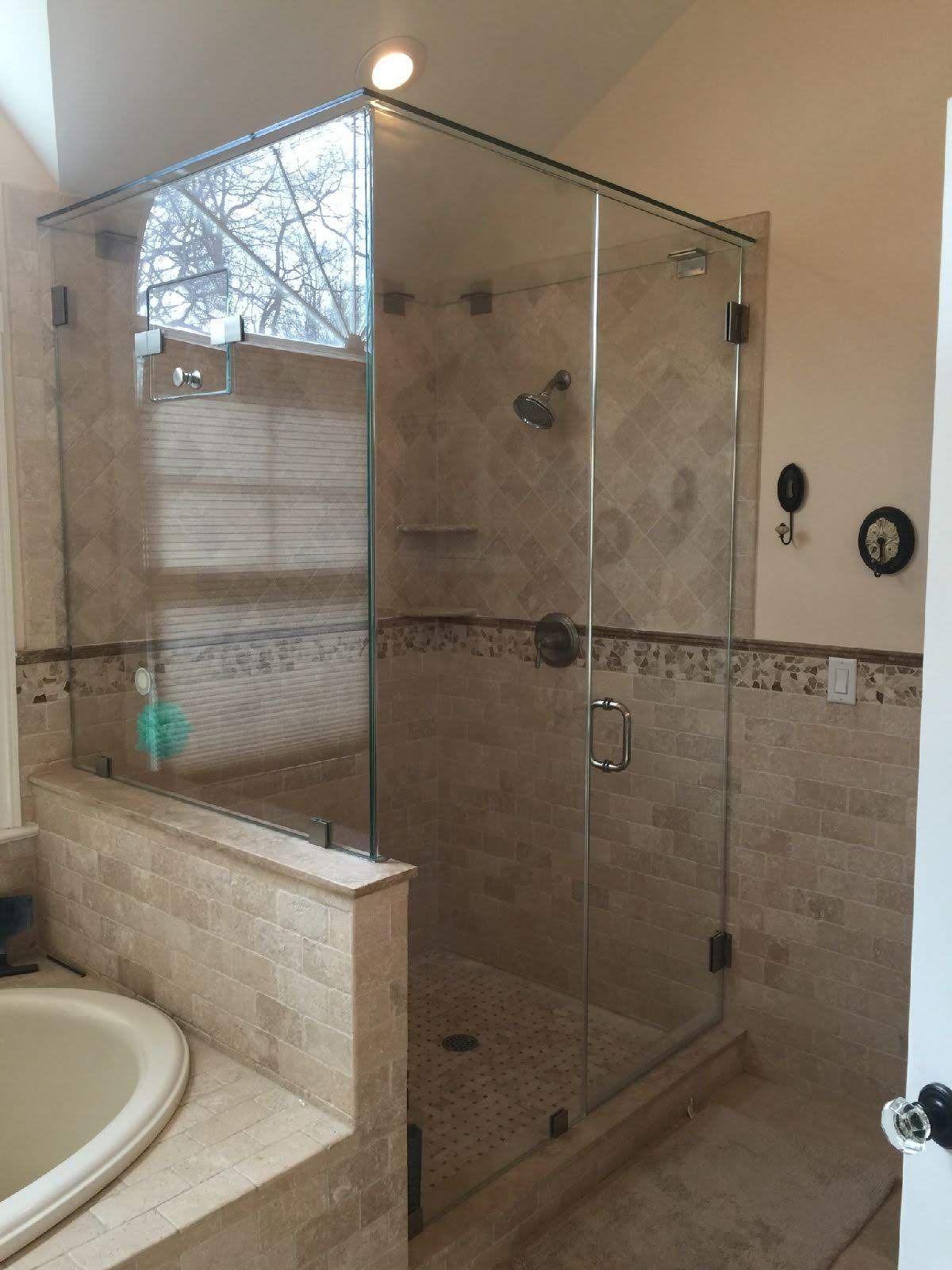 a bathroom with a tub and a shower with a glass door.