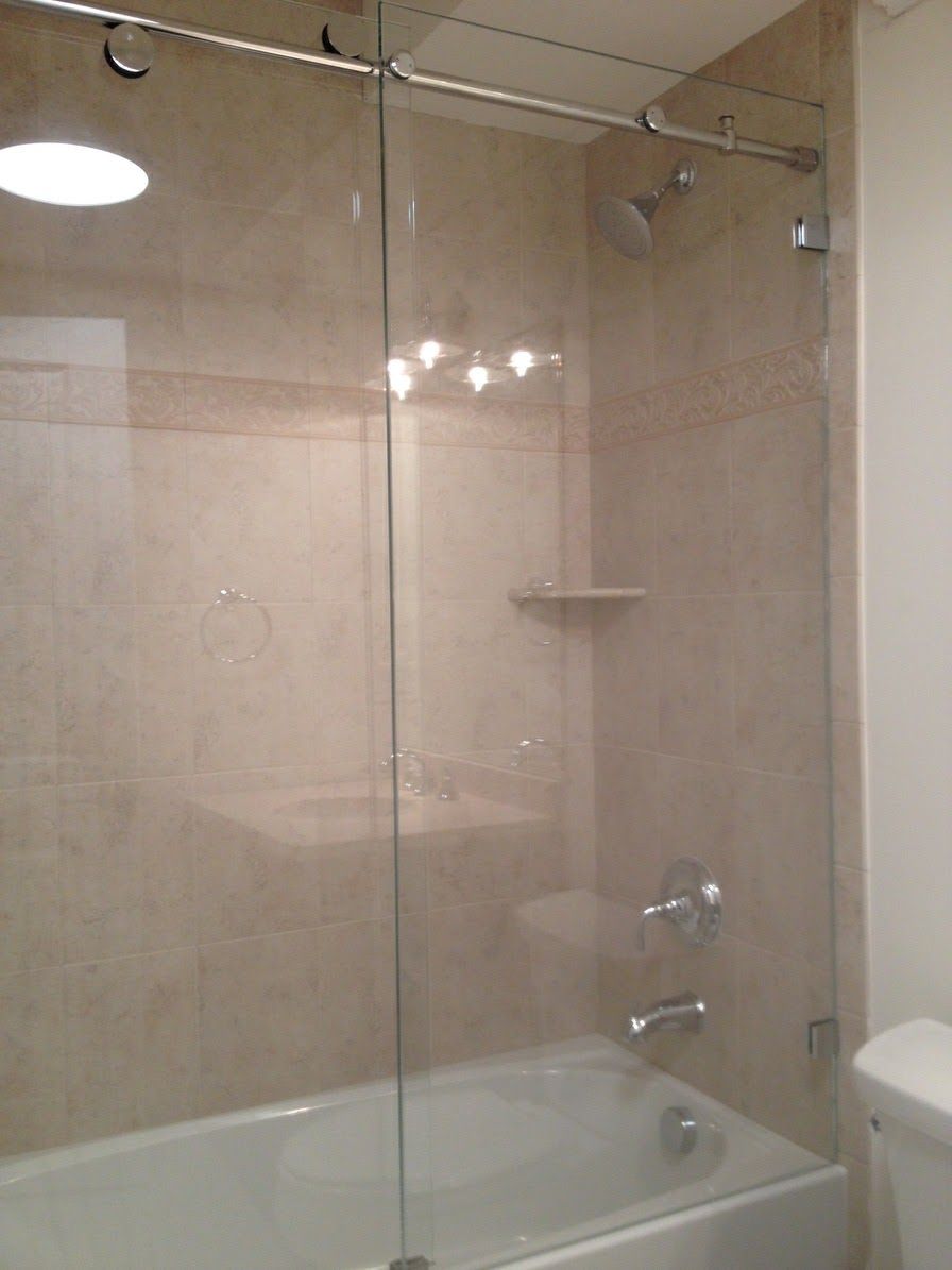 a bathroom with a bathtub and a glass shower door.