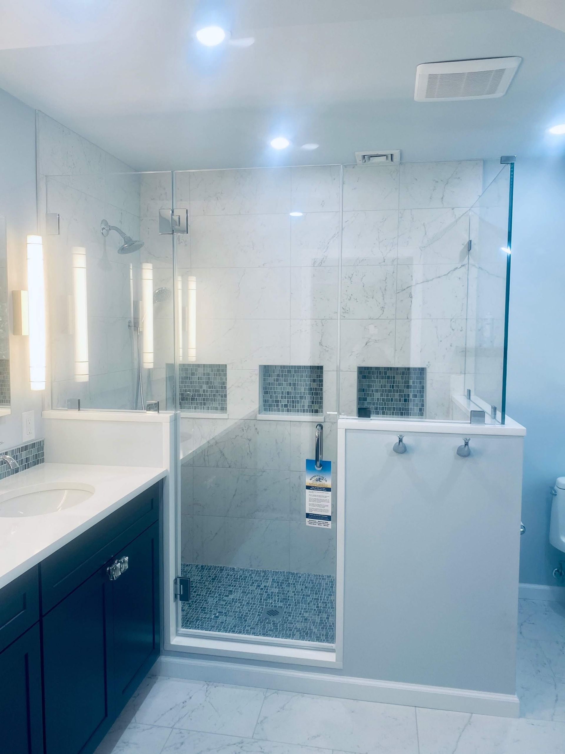 a bathroom with a walk in shower and a sink.