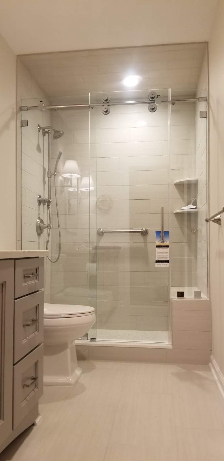 a bathroom with a toilet , sink , shower and sliding glass door.