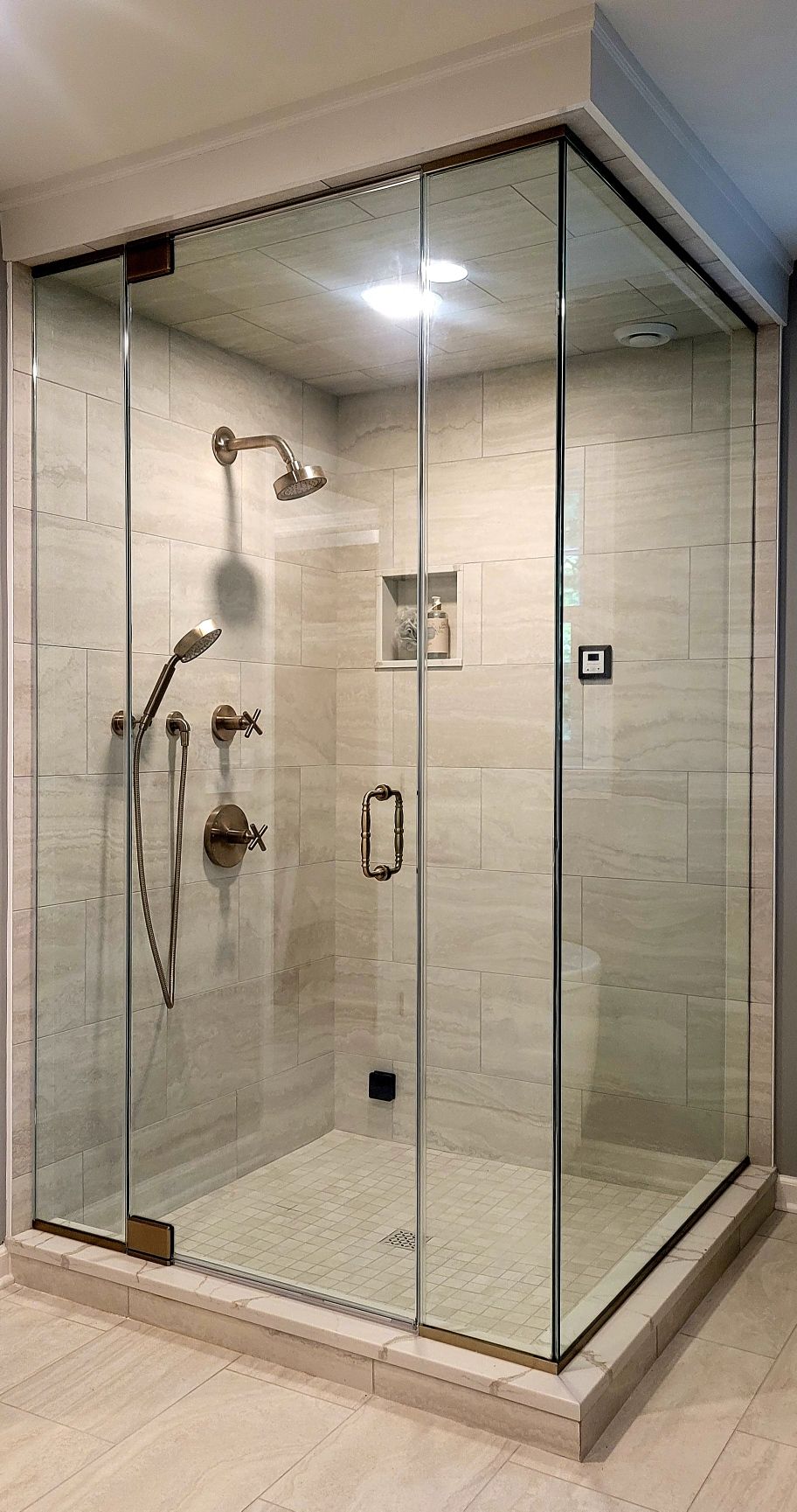a shower stall with a glass door and a shower head in a bathroom.