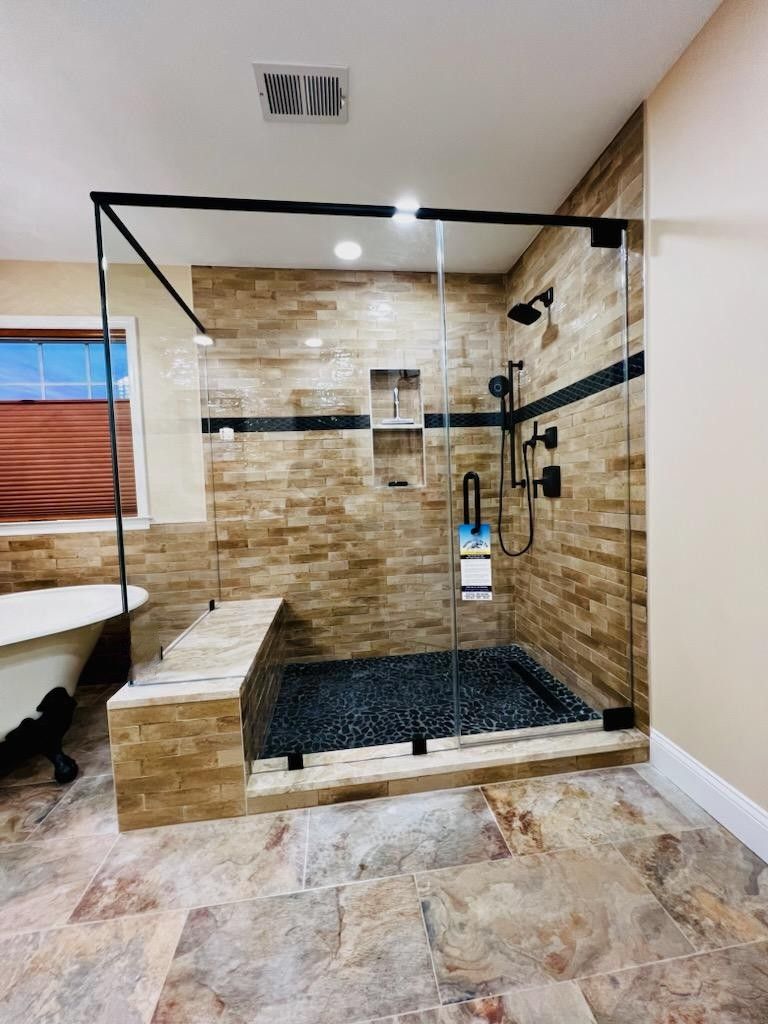 a bathroom with a walk in shower and a tub.