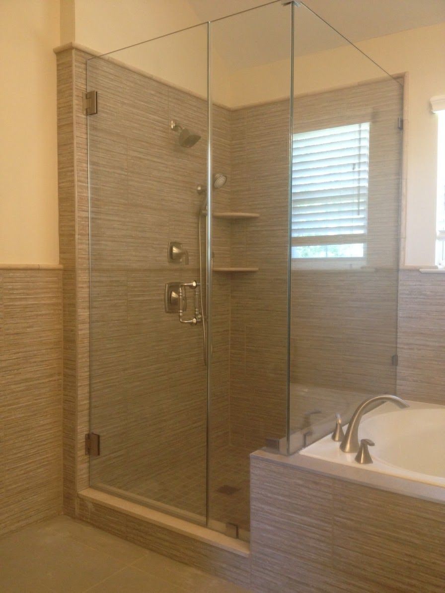 a bathroom with a tub and a shower with a glass door.