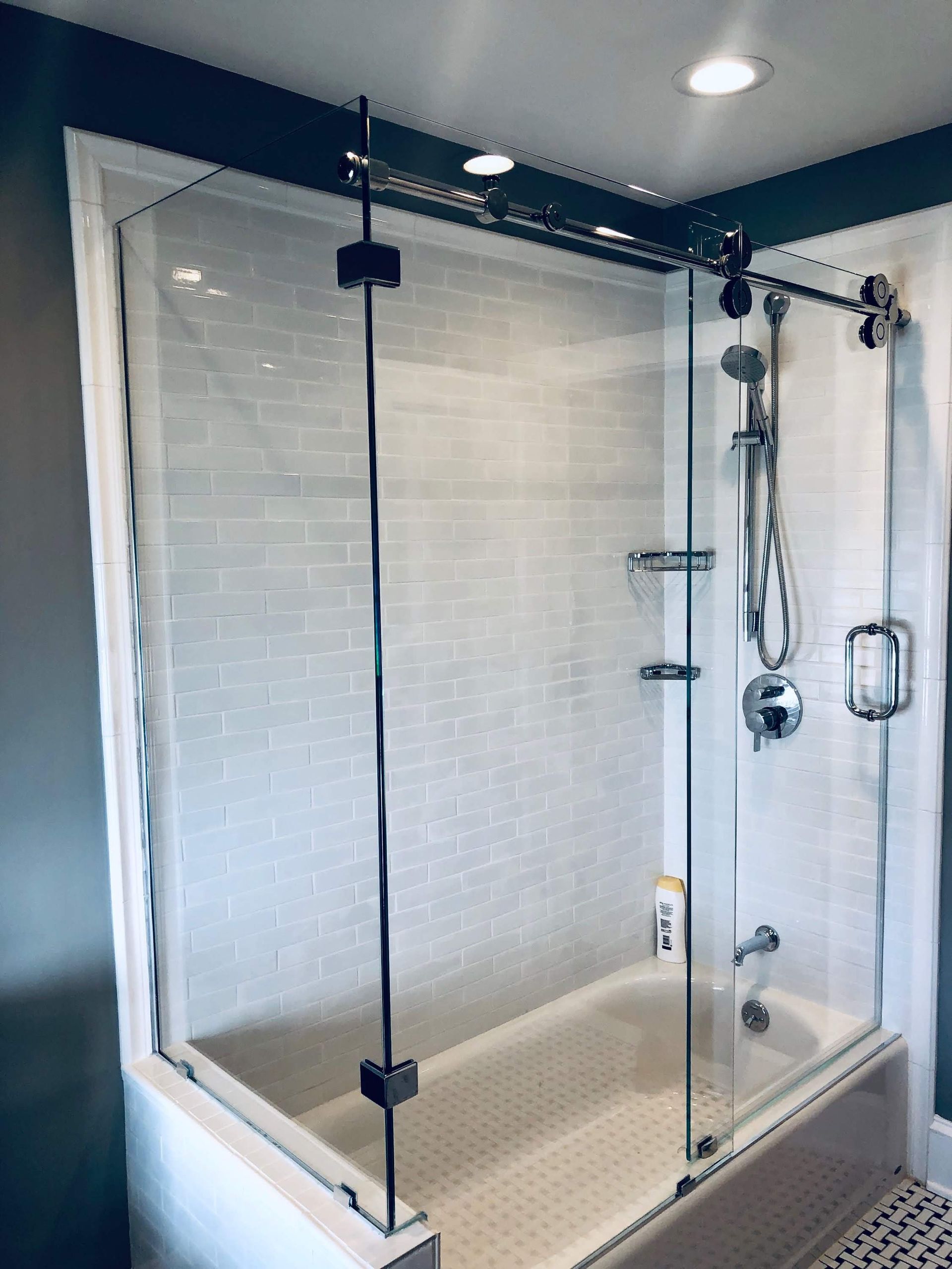a bathroom with a bathtub and a shower stall with sliding glass doors.