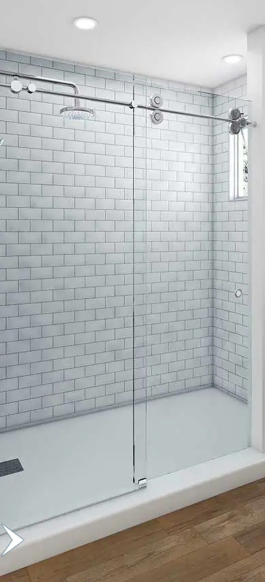 a bathroom with white brick walls and a walk in shower with a sliding glass door.