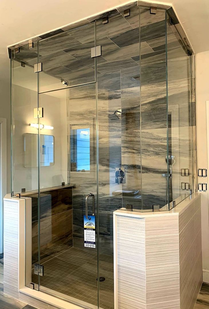 a bathroom with a walk in shower and a glass door.