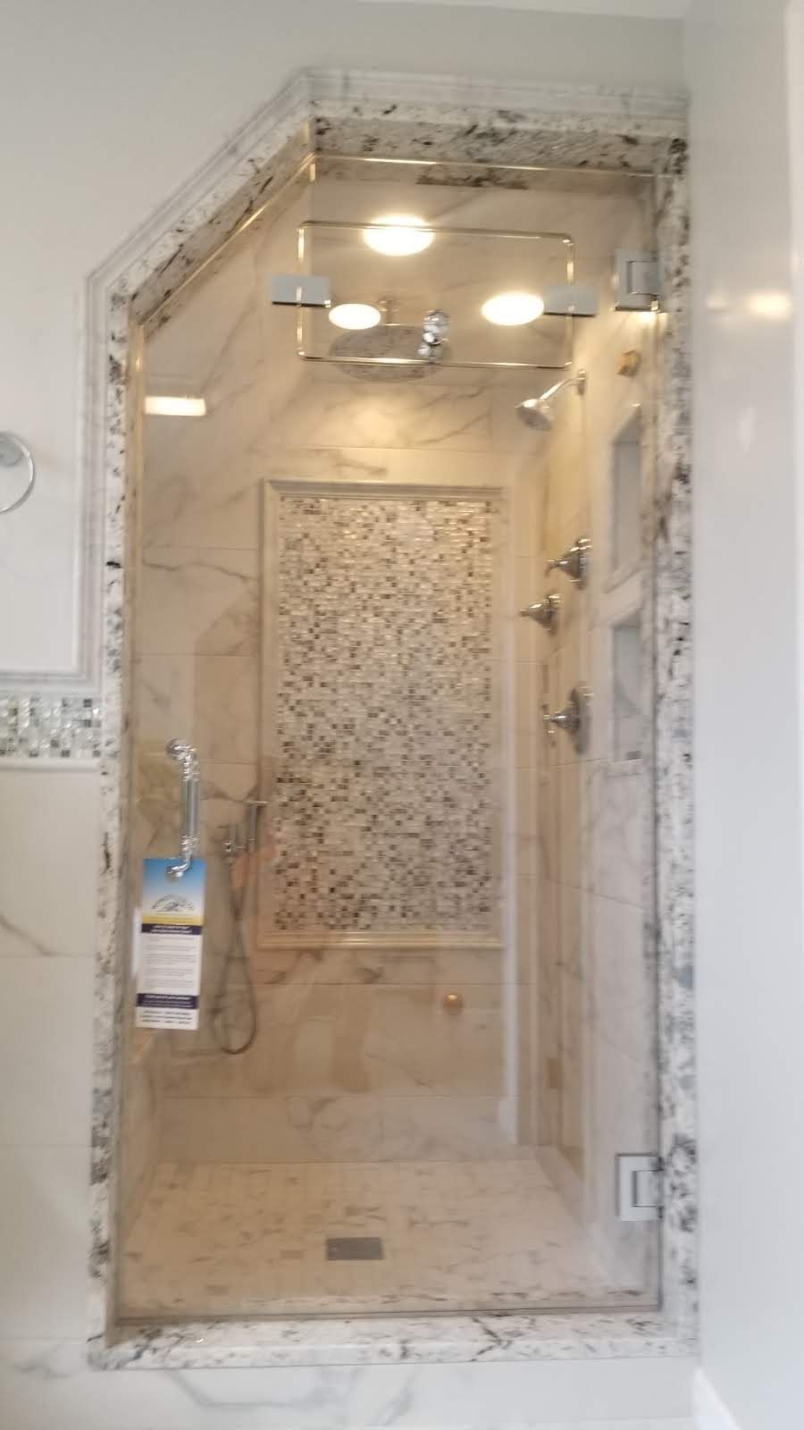 a bathroom with a walk in shower with a glass door.