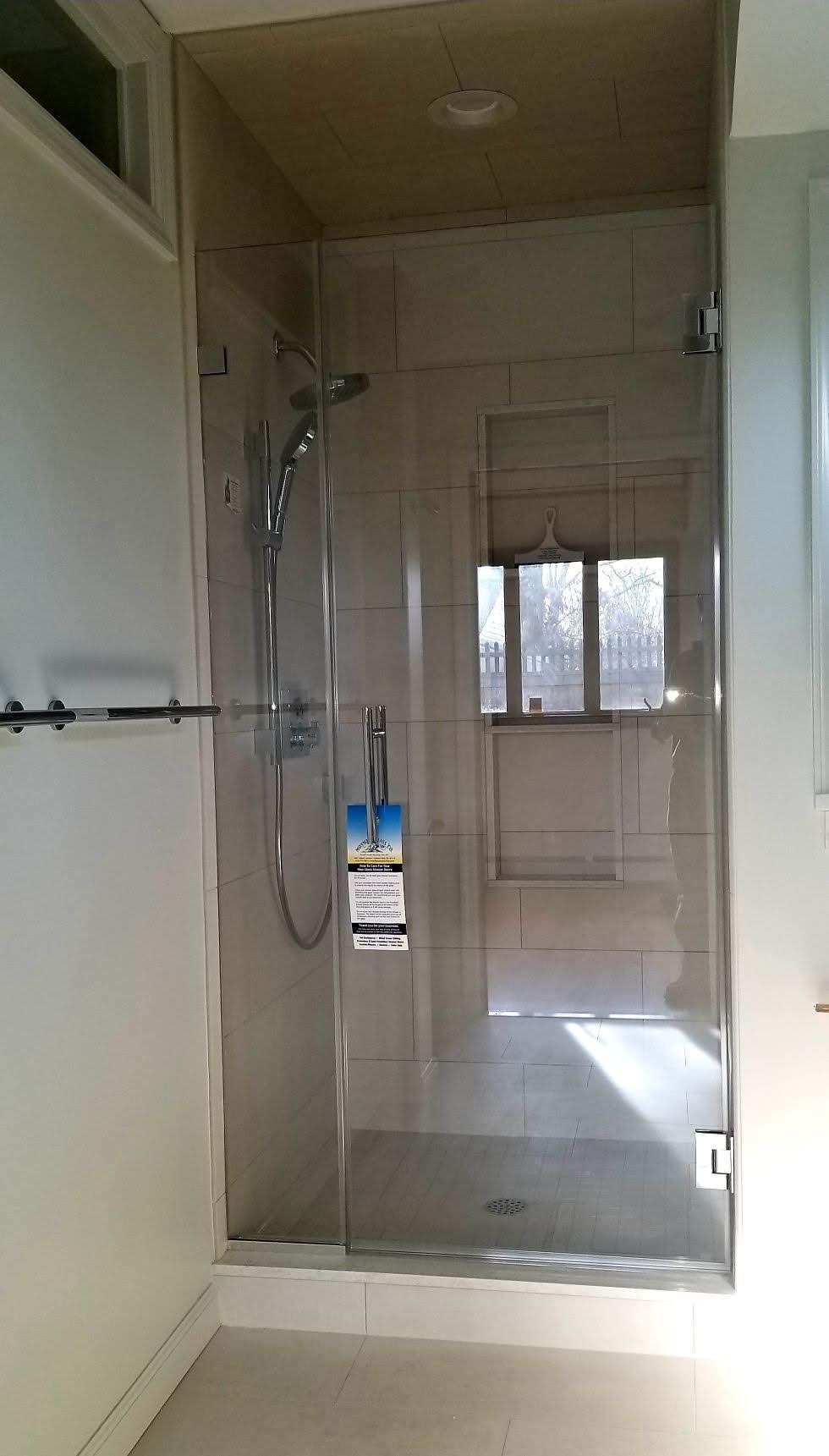 a bathroom with a walk in shower and a window.