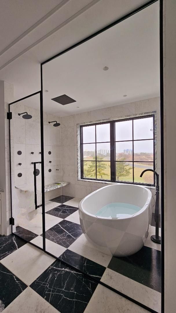 a bathroom with a bathtub , shower , and checkered floor.
