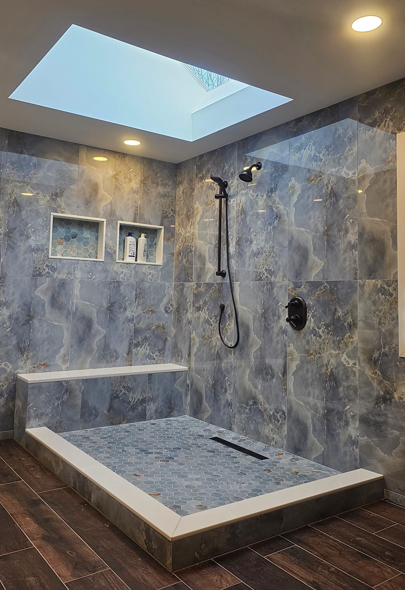a bathroom with a walk-in shower and a skylight.