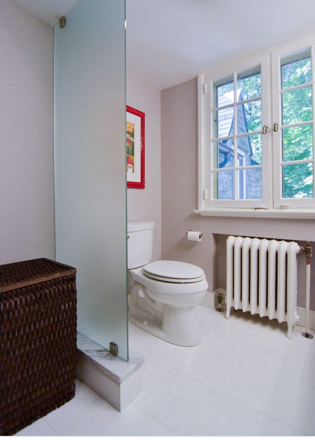 a bathroom with a toilet a radiator and a window.