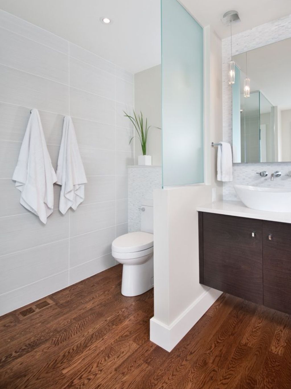 a bathroom with a toilet, sink, and mirror.