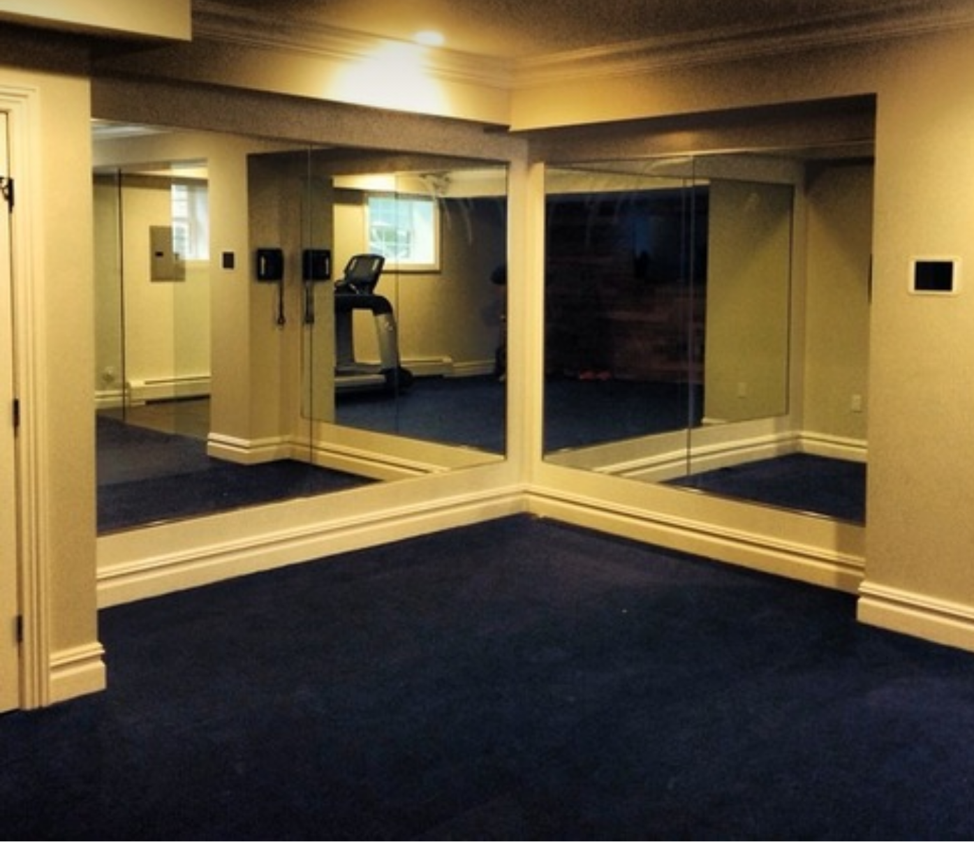 a room with a treadmill and a lot of mirrors.