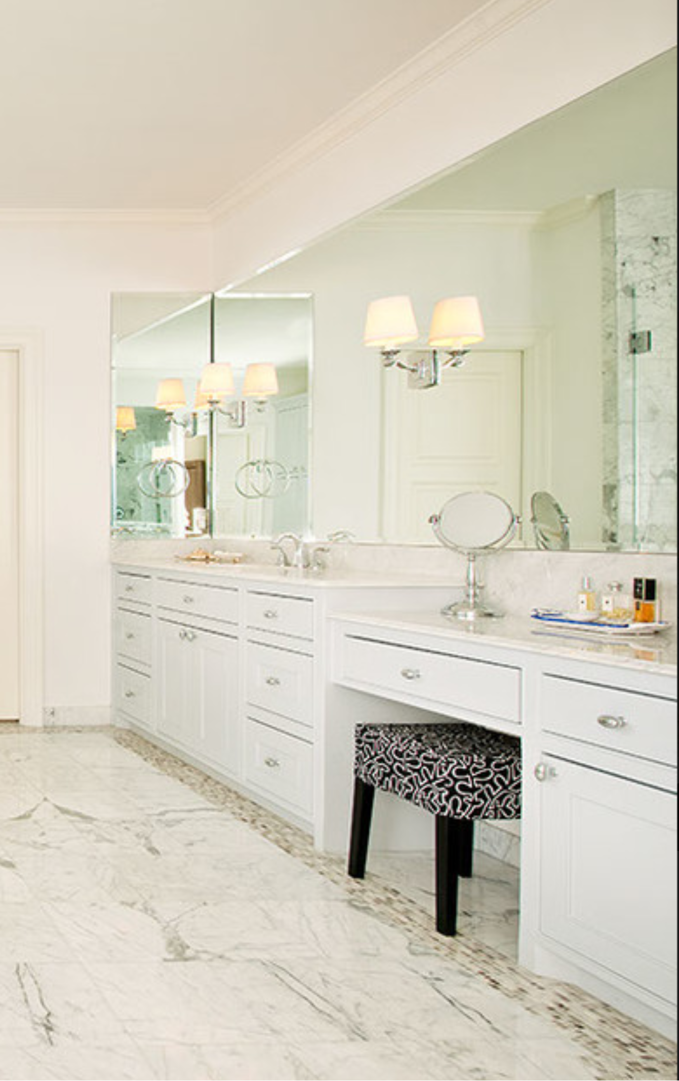 a bathroom with a vanity, mirror, and stool.
