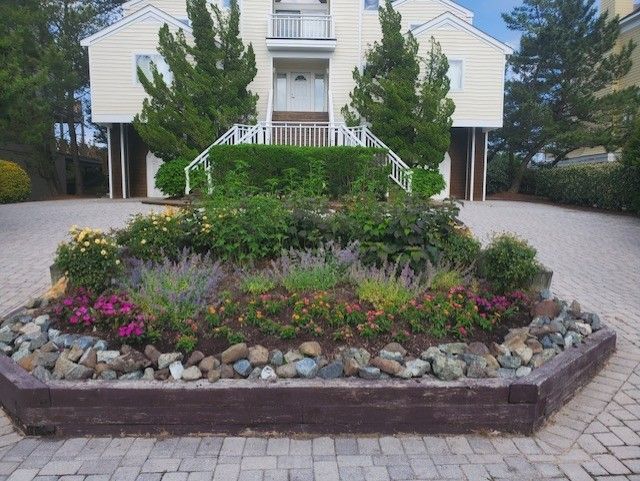 A house with a brick driveway and a garden in front of it