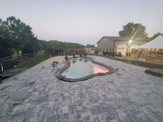 A large swimming pool is being built in the backyard of a house.