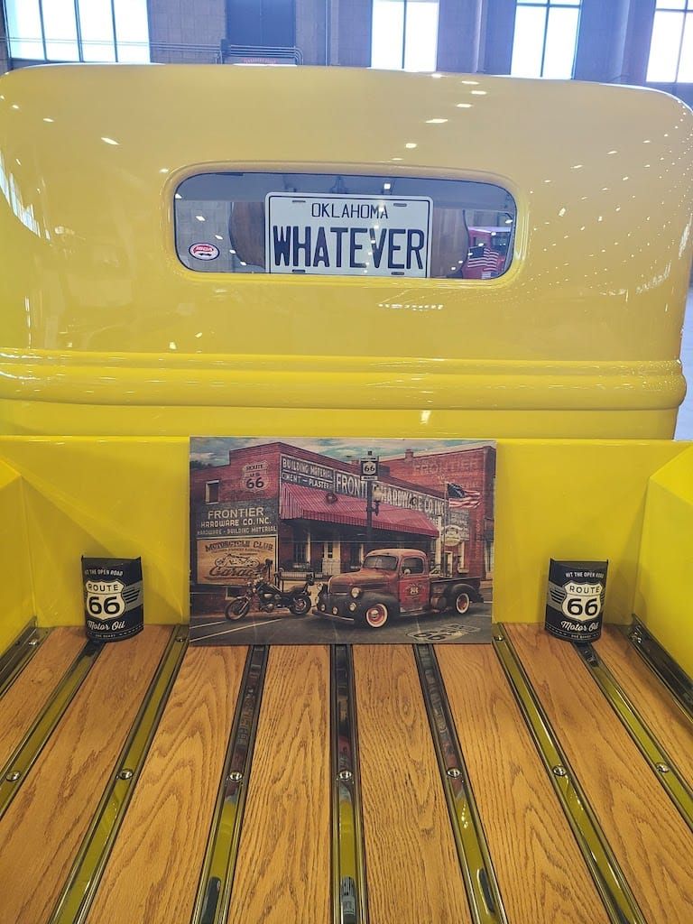 Yellow pickup truck bed with wooden planks, license plate reading