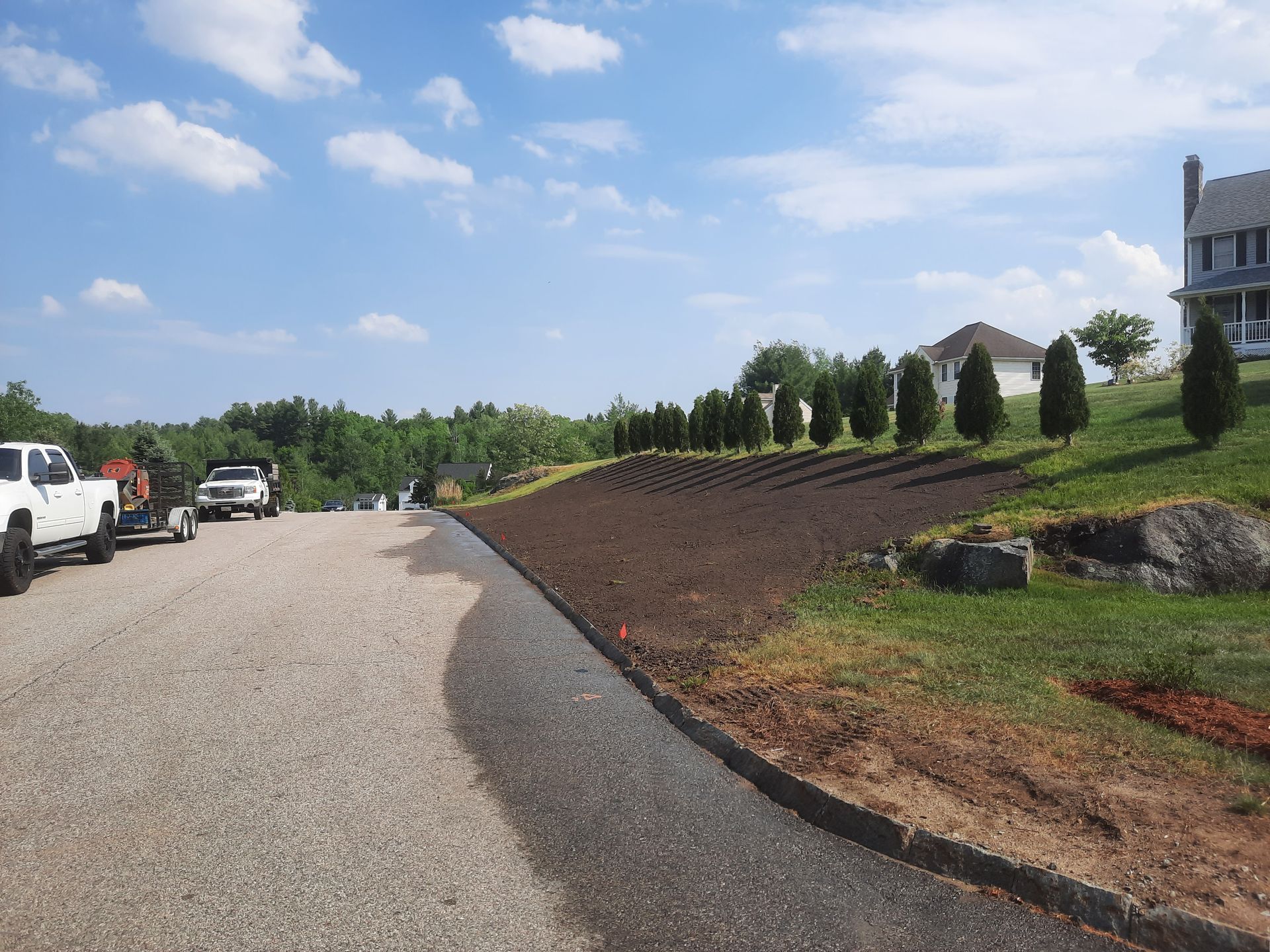 a gravel road with a house in the background