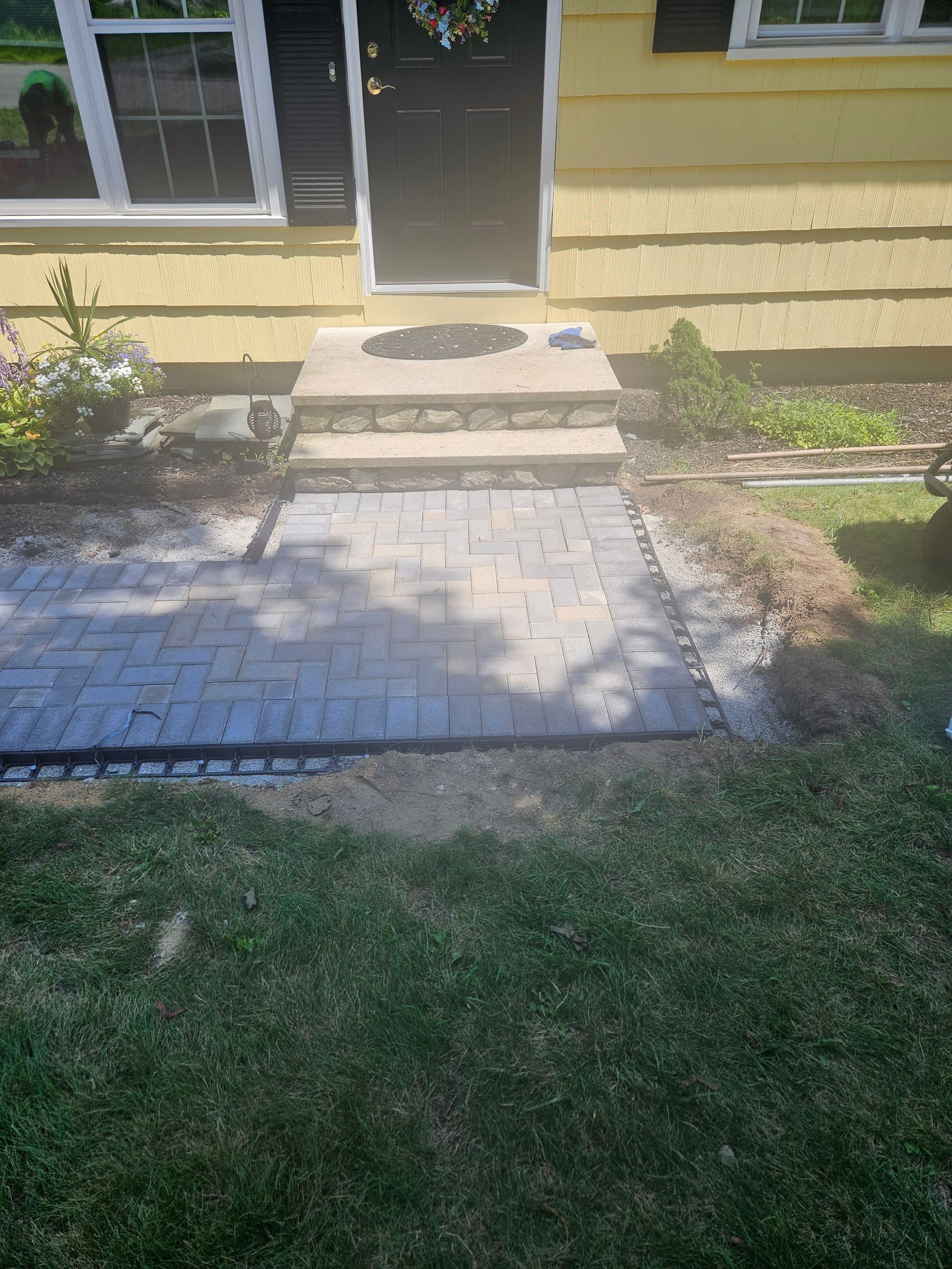 there is a brick walkway leading to the front door of a house