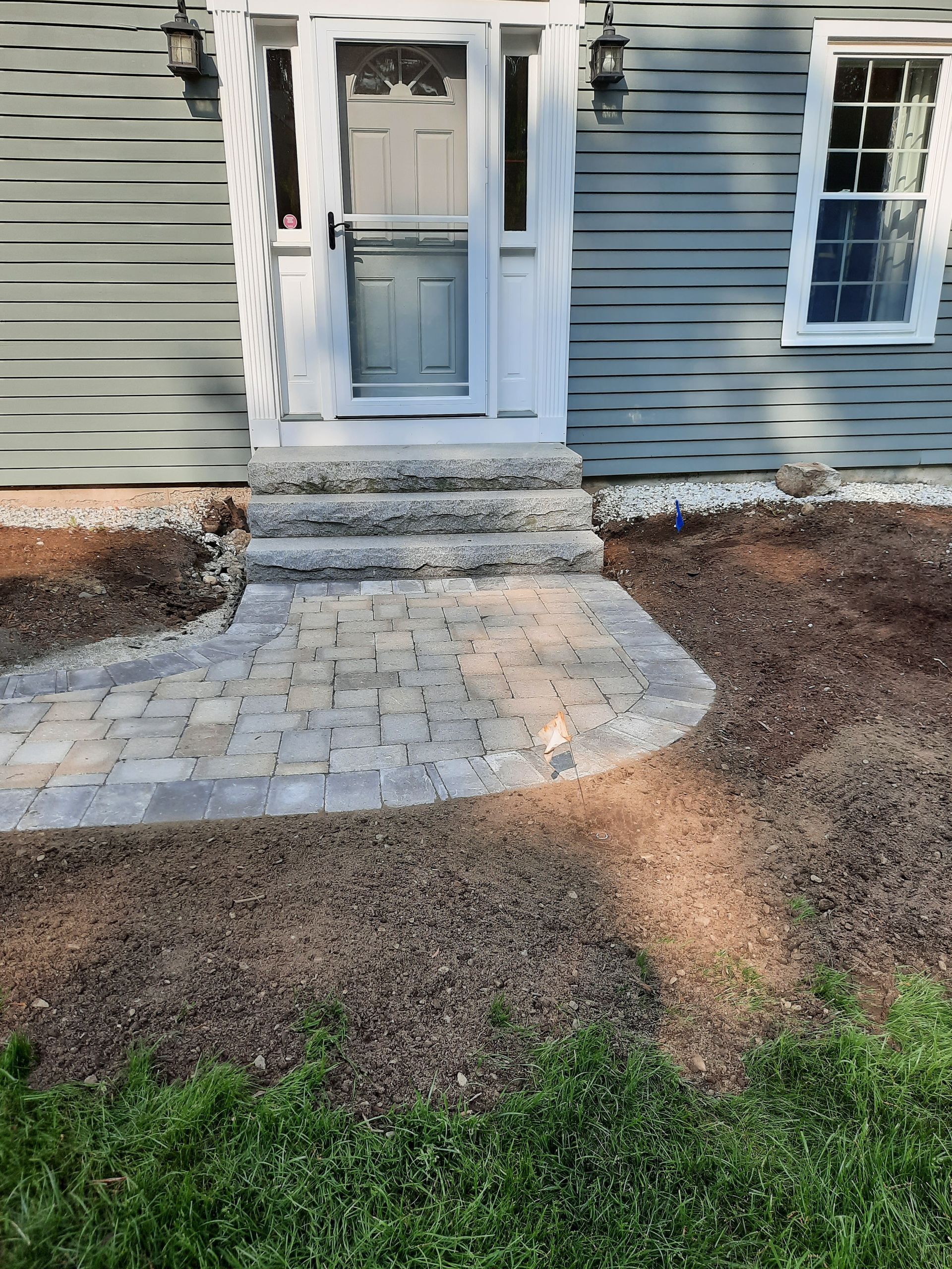 there is a brick walkway leading to the front door of a house