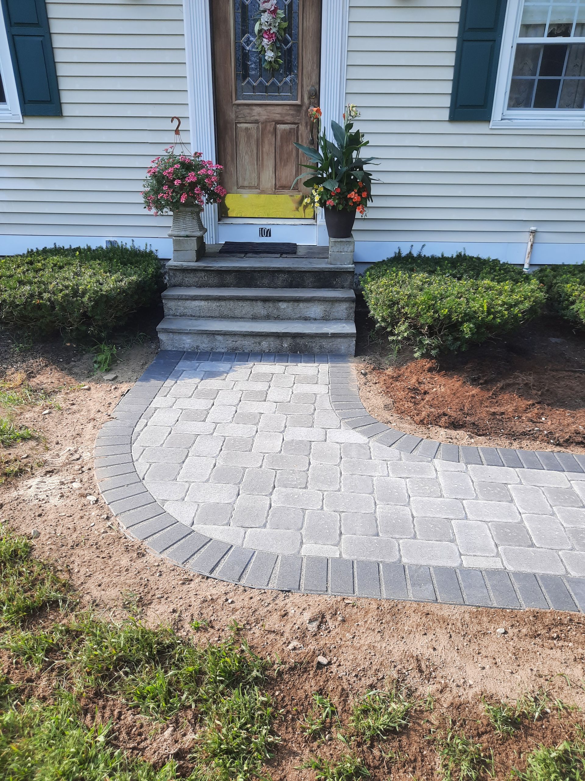 a brick walkway leading to the front door of a house