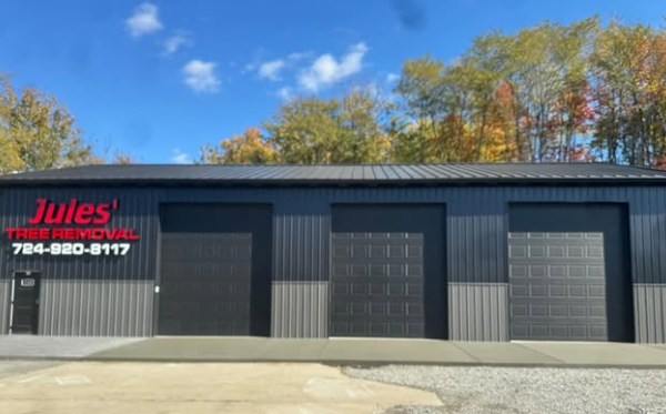 Jules Tire Pros storefront with three garage doors and red sign on a sunny day