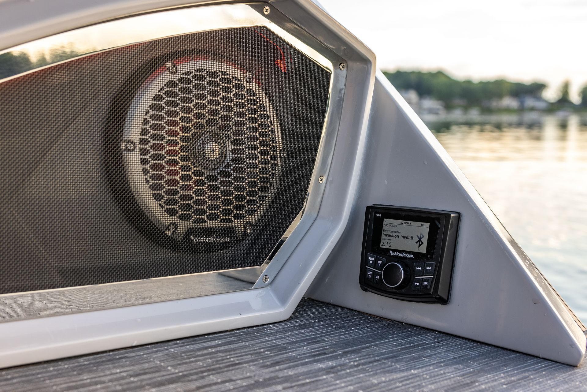 Boat deck speaker and control panel by the water at sunset