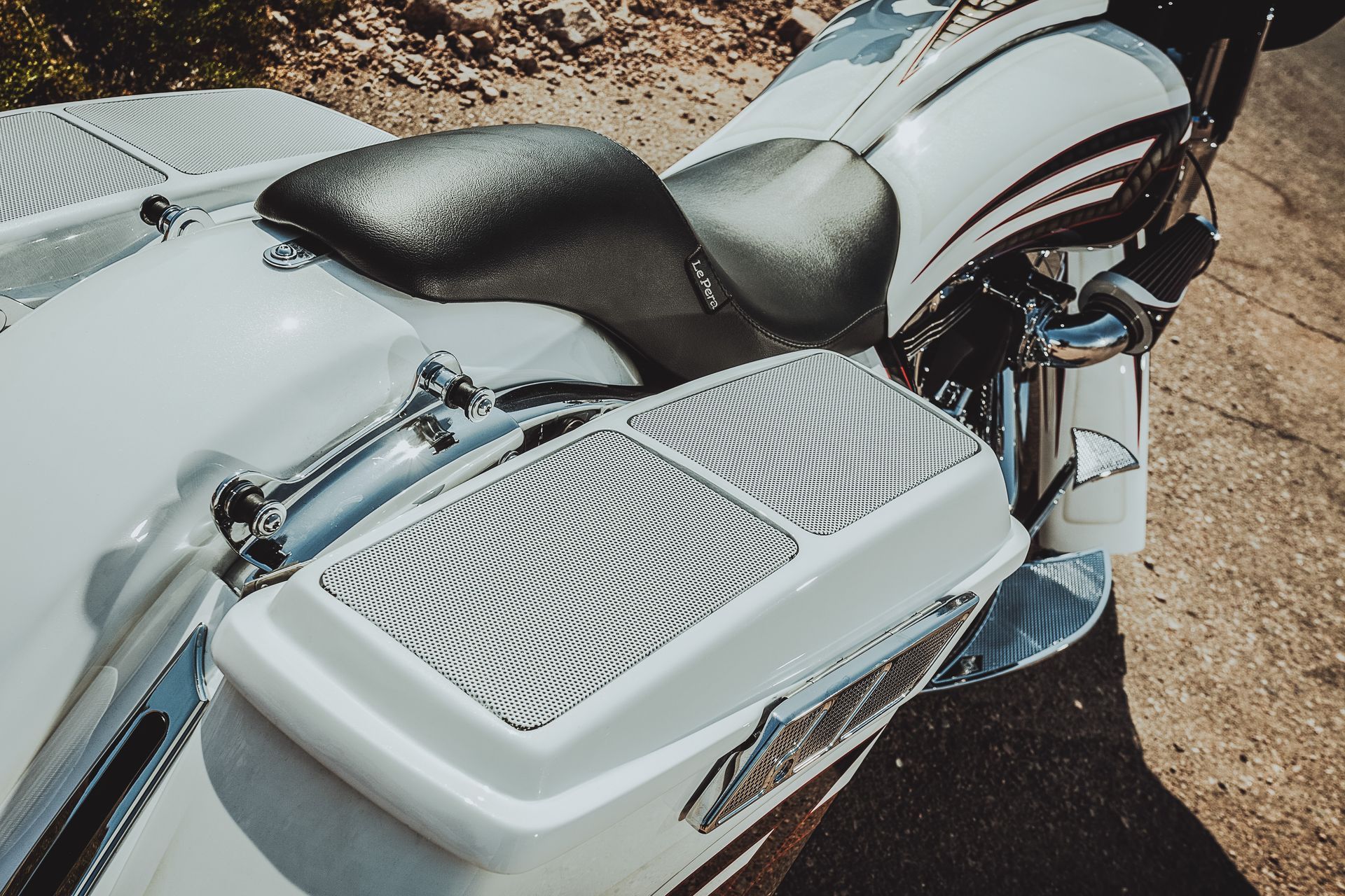 Chrome motorcycle with black seat and silver side panel parked on a dirt surface